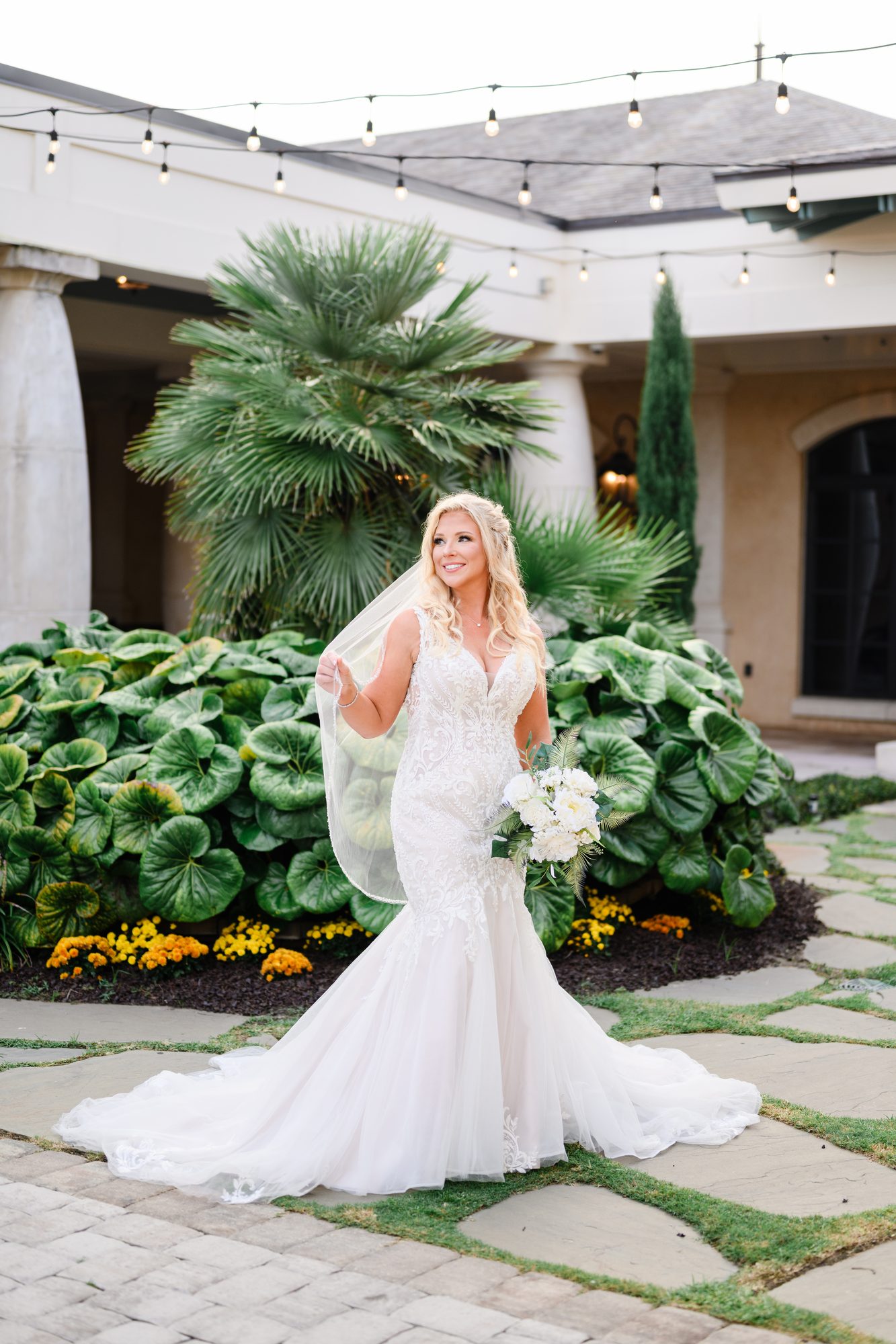 Olivia in a fitted lace gown in the Courtyard at 21 Main Events