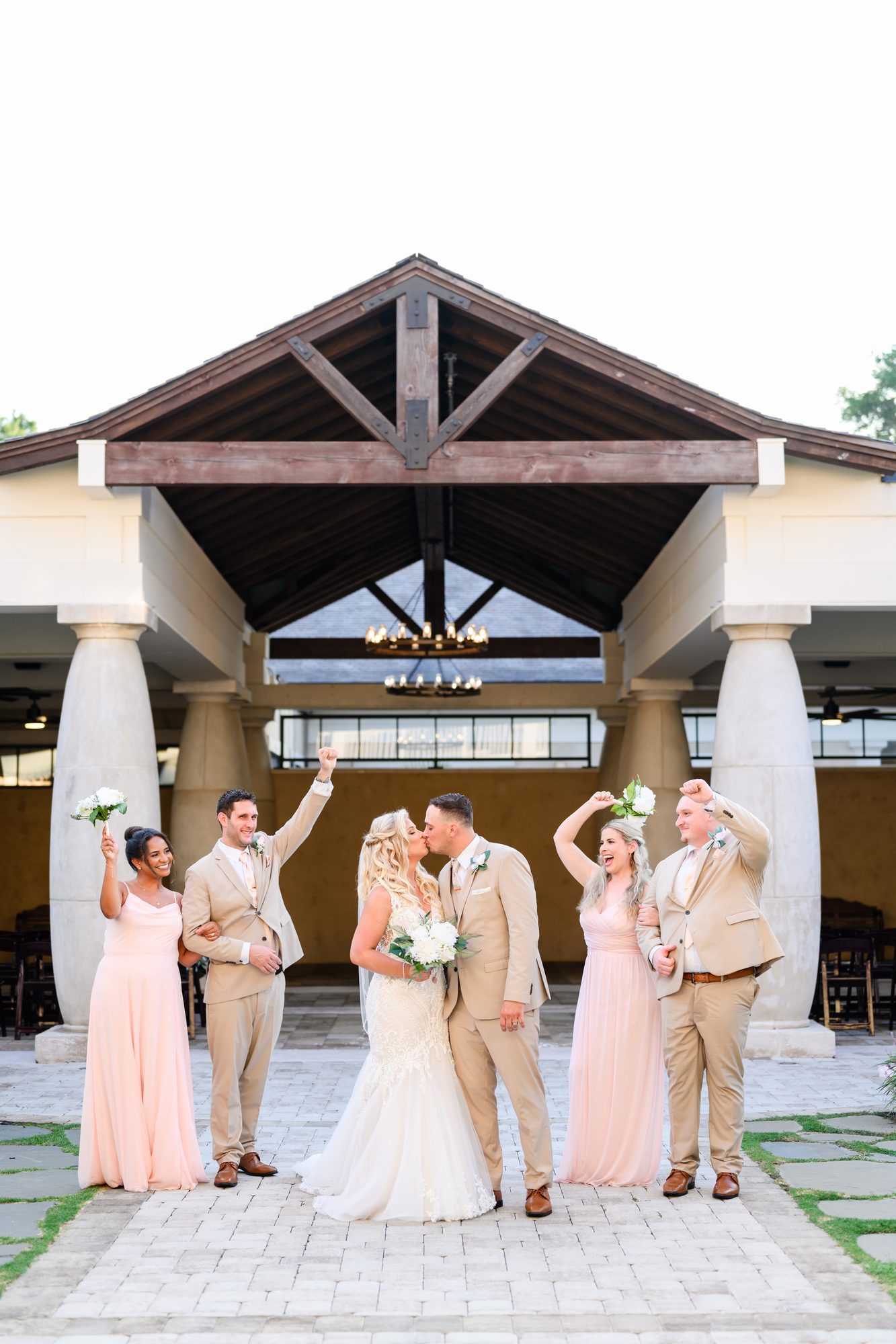 Olivia and Robert cheering with their wedding party under the covered entrance at 21 Main