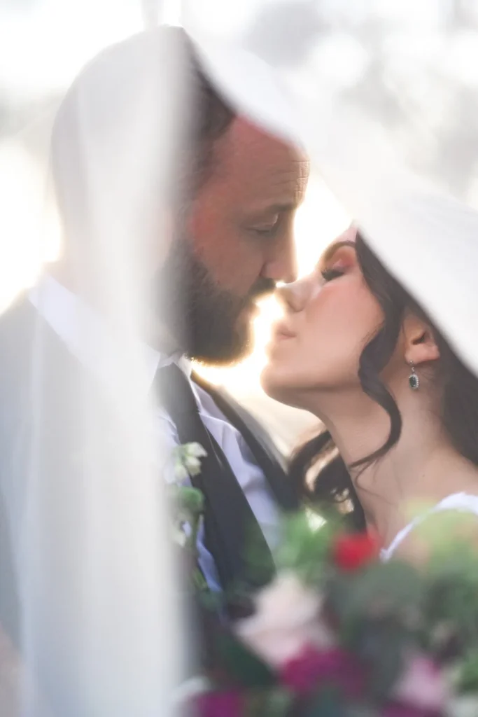 Aerianna and Mark sharing a kiss beneath her veil at Wachesaw Plantation Club