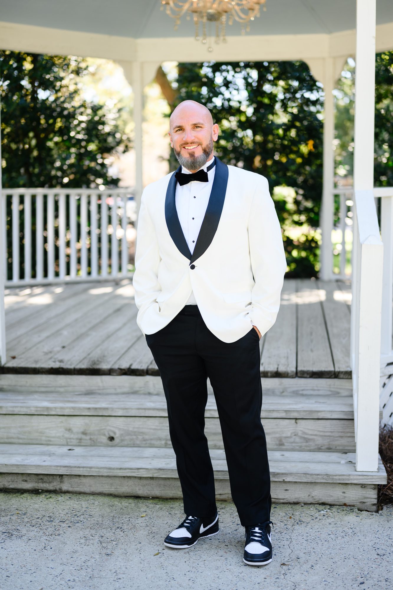 Eddie in a white tuxedo jacket and sneakers on the gazebo steps at The Village House