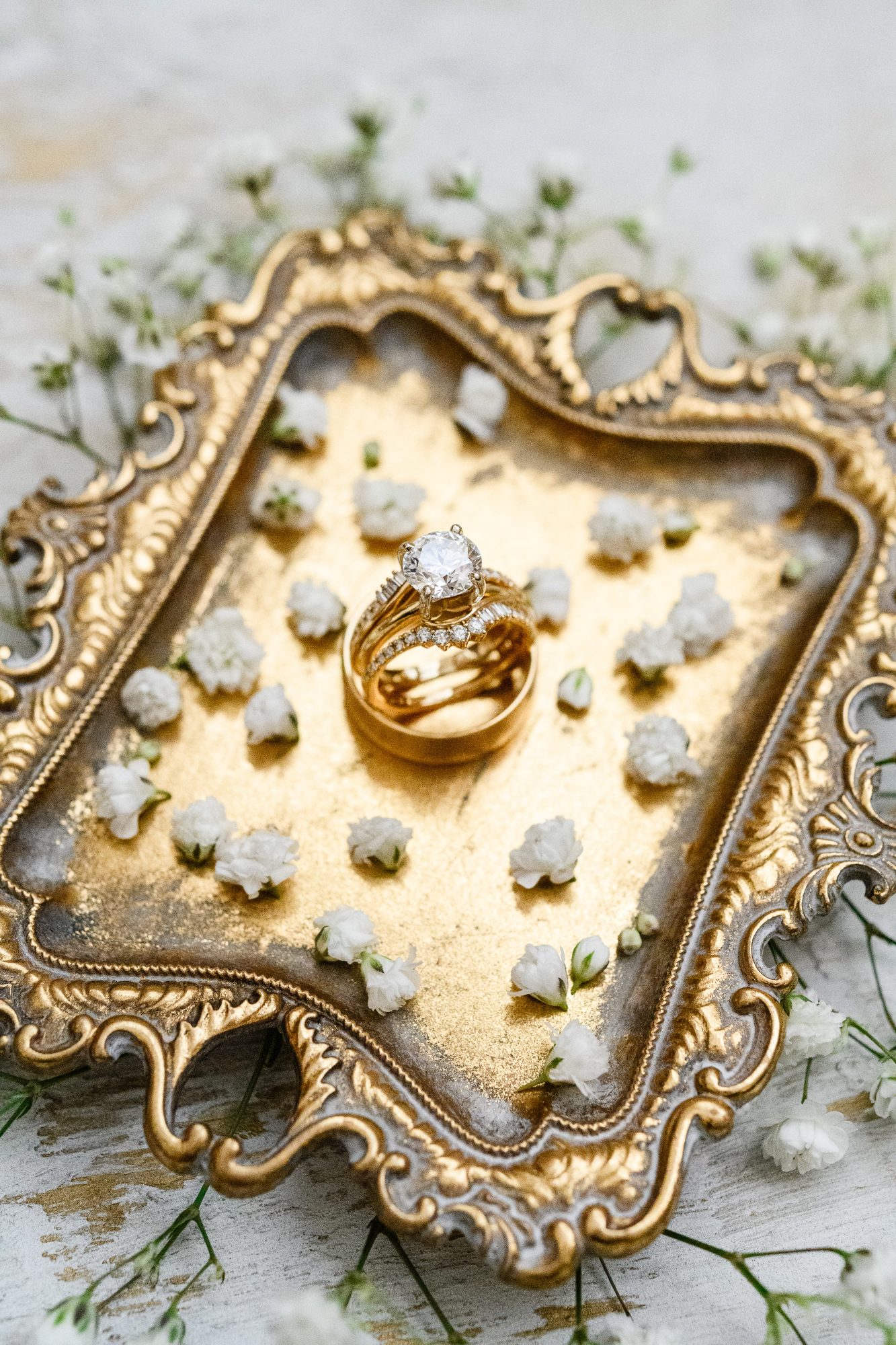 Shannon and Eddie's wedding rings on an ornate gold tray with baby's breath