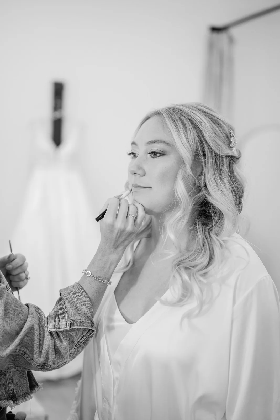 Black and white photo of the bride having her makeup finished on her White Oaks Farm wedding day